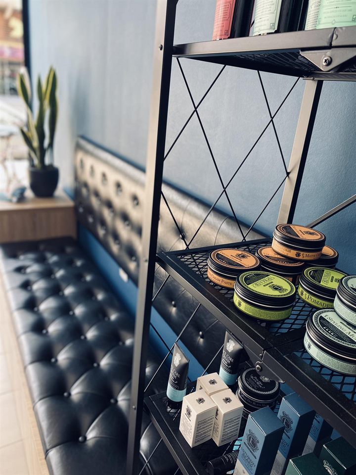 Ράφι με pomades και κρέμες περιποίησης προσώπου δίπλα στον καναπέ αναμονής